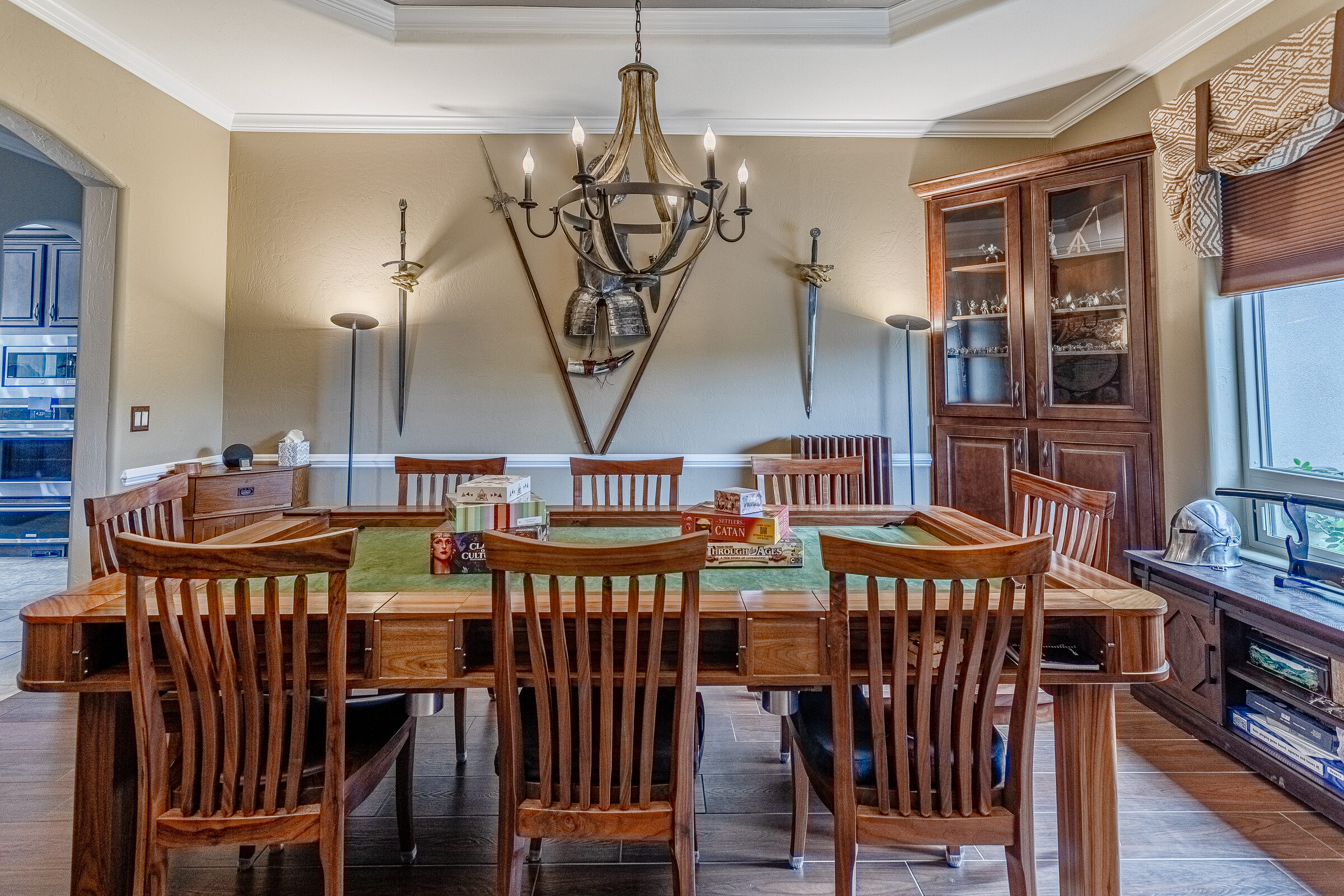 Game room — custom gaming table with display cabinets and swords